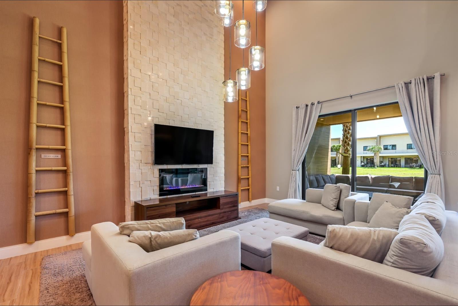 Family room with Fireplace, TV and stone wall that goes all the way to the celing. - 7482 BROOKLYN DR, KISSIMMEE