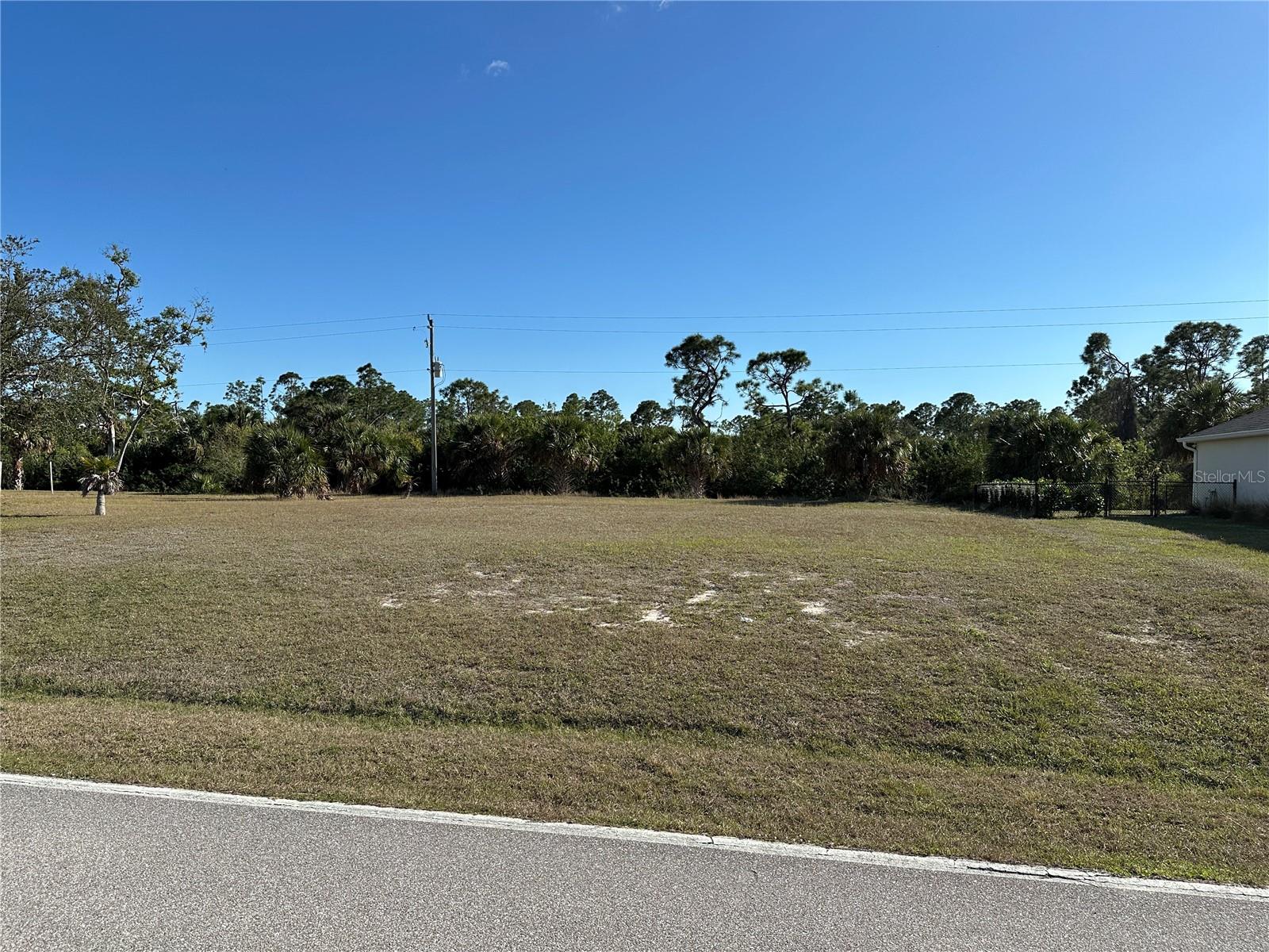 This photo was taken by a 6'1" man standing in the road.  You can see how much this homesite has been filled. - 25623 PRADA DR, PUNTA GORDA