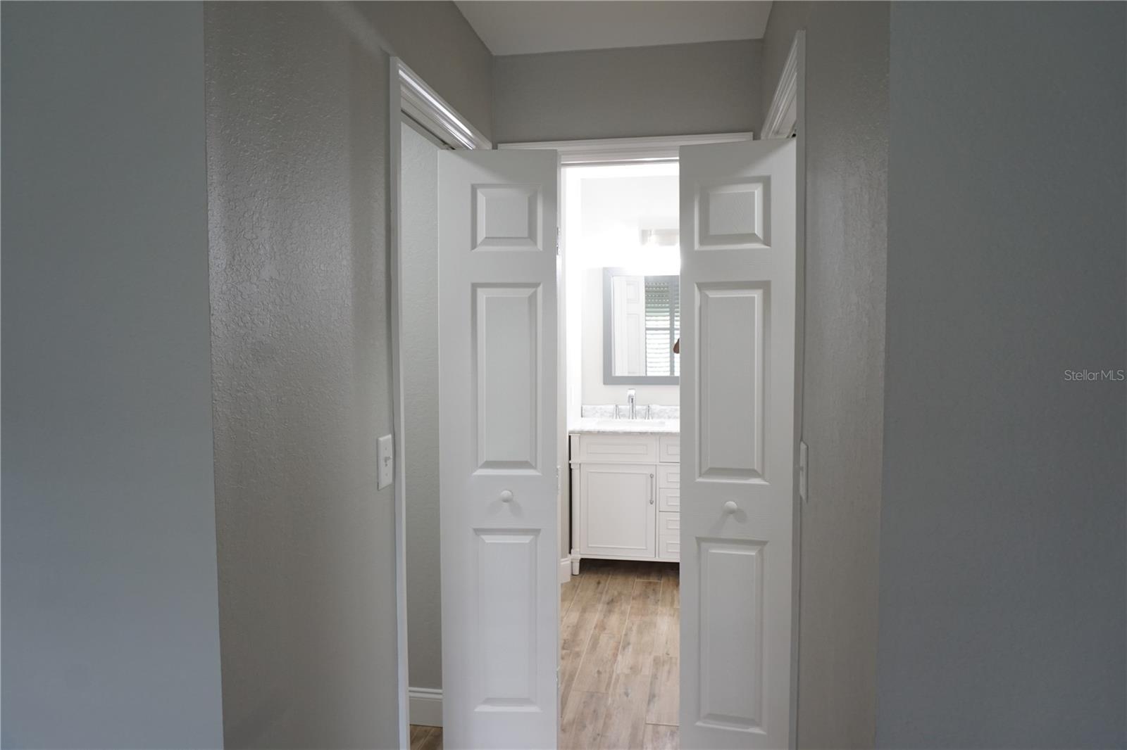 Primary bedroom hall into bathroom with walk-in closets on both sides - 2000 BAL HARBOR BLVD #1012, PUNTA GORDA