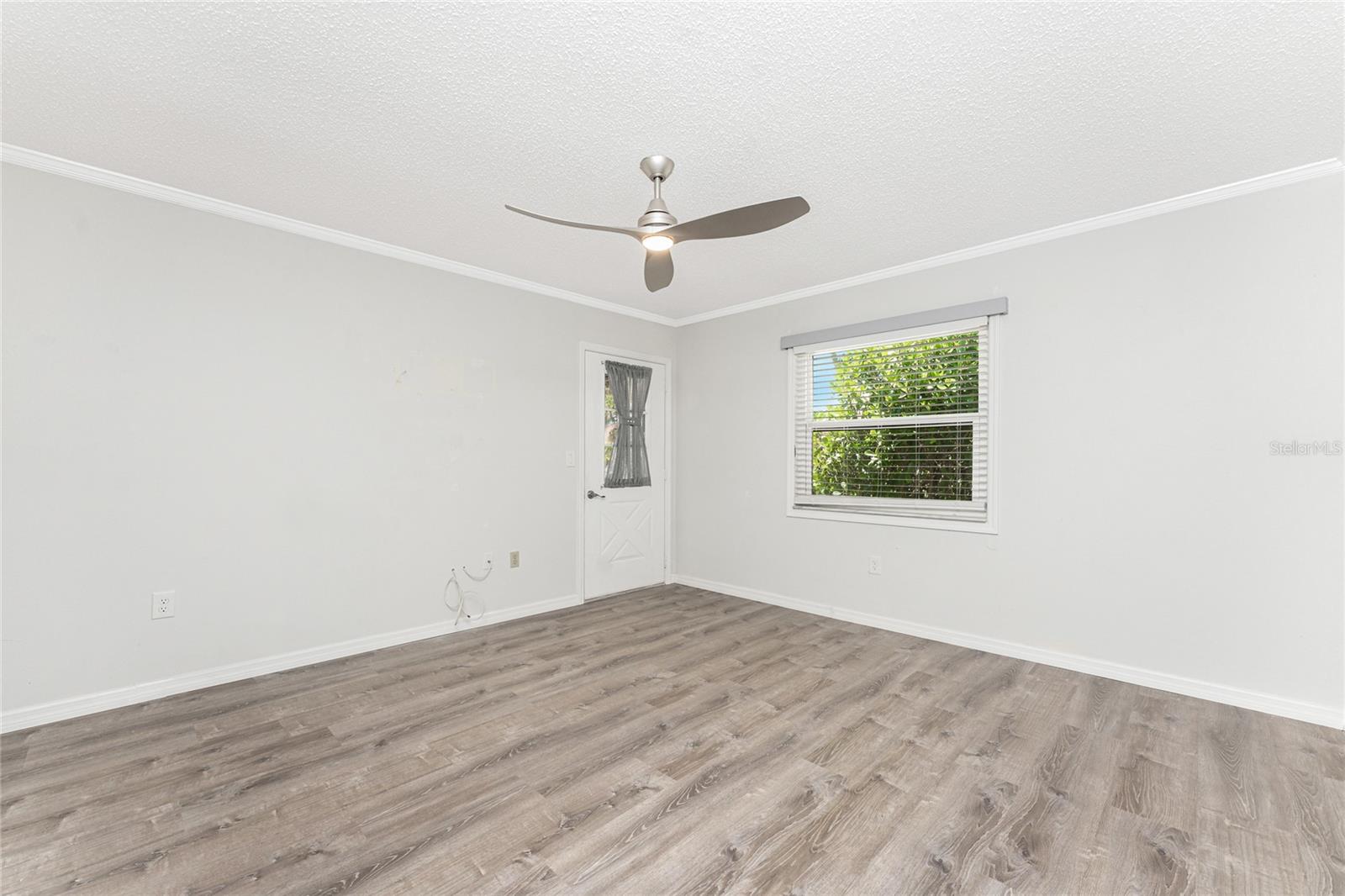 Primary bedroom has laminate flooring and door to the Lanai - 6796 GASPARILLA PINES BLVD #63, ENGLEWOOD