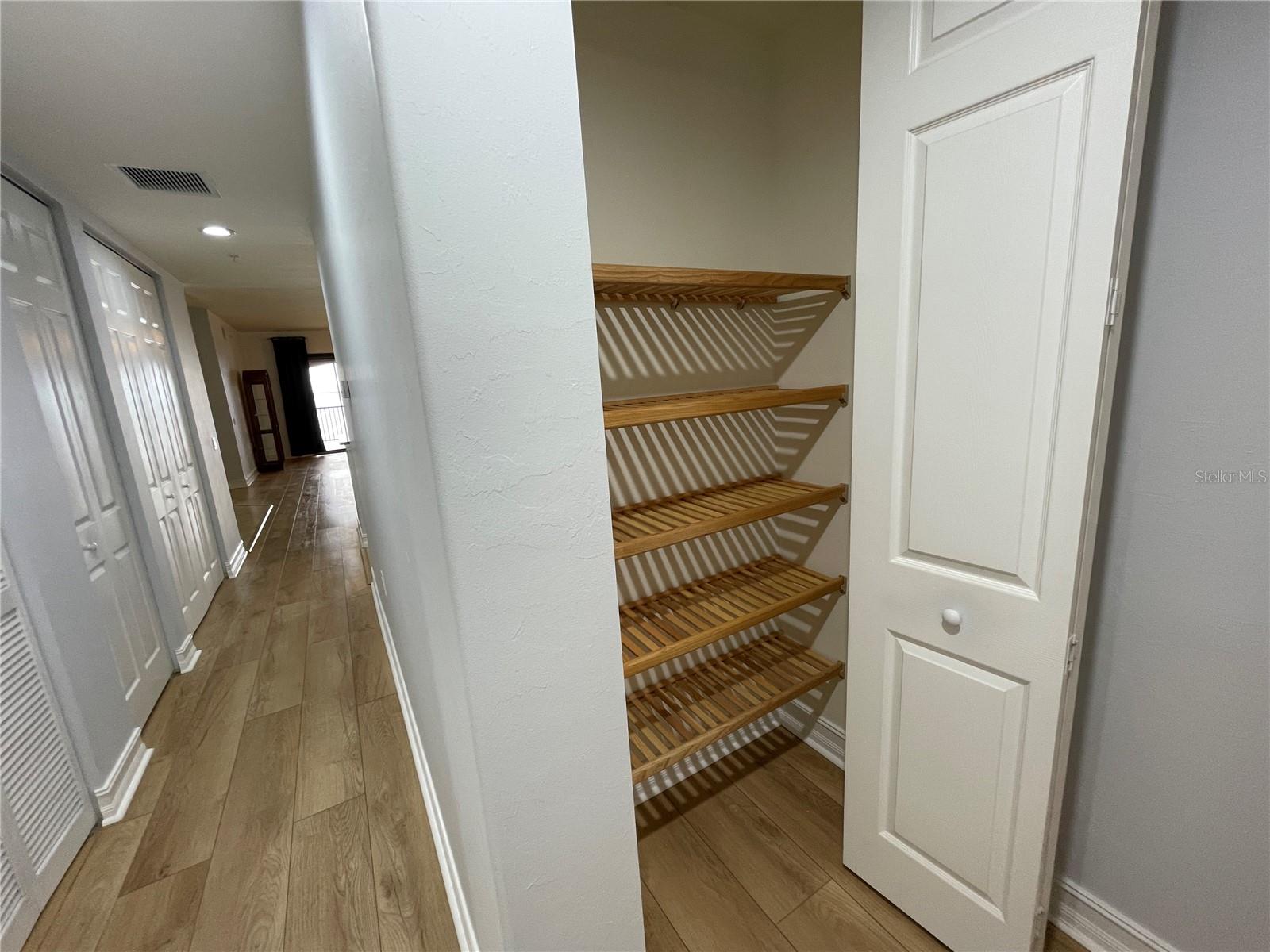 Hallway from the guest side of the home looking to the living area, showing many of the closets - 85 VIVANTE BLVD #8534, PUNTA GORDA
