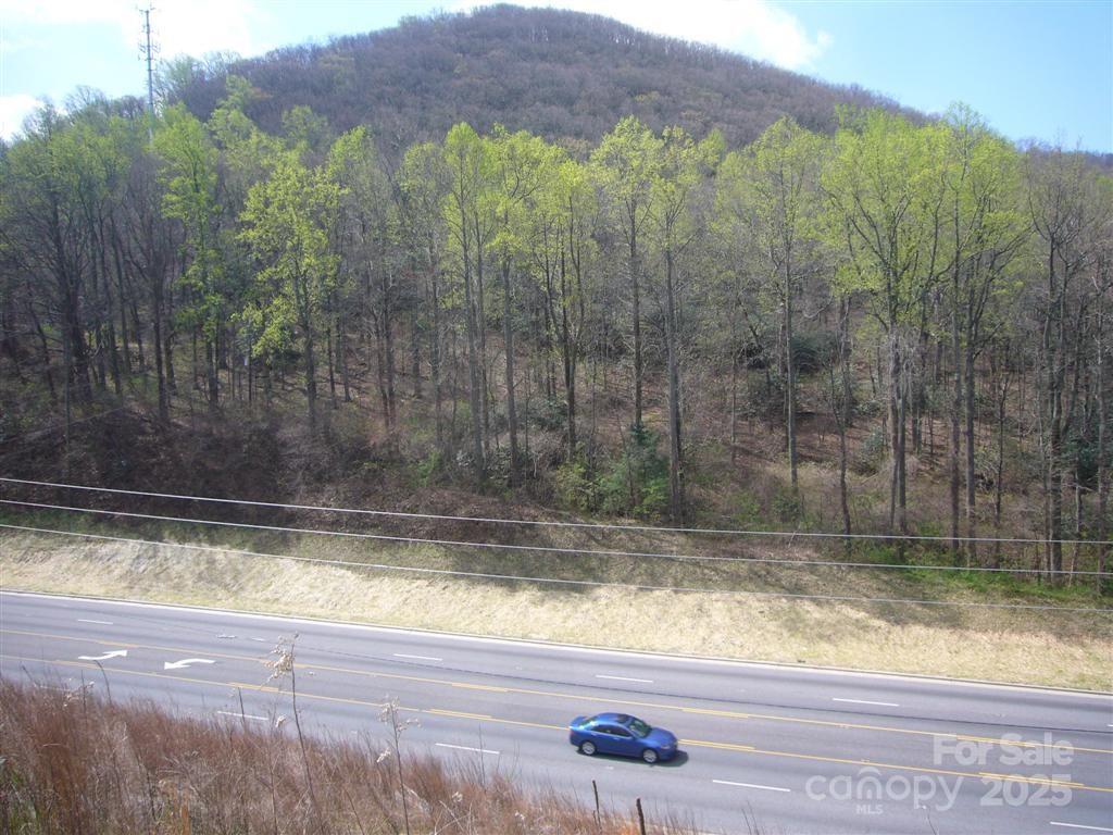 View of 10 acres from across Hwy 74A showing level building areas. - 10 acres Charlotte Highway, Asheville