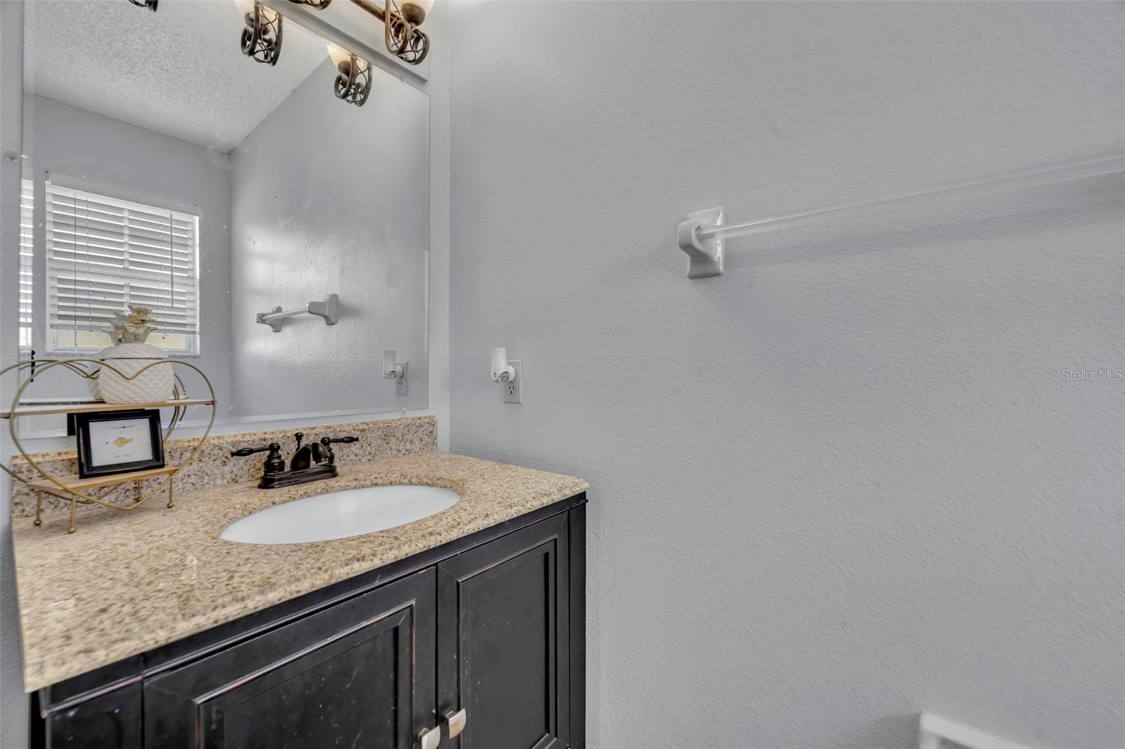 Downstairs, half bath vanity with marble countertop. - 2810 CORNERSTONE CT, APOPKA