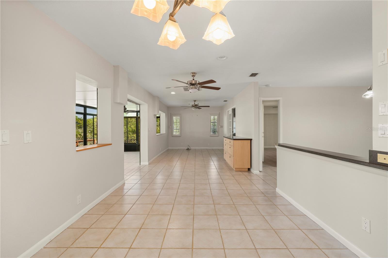Bonus Room with the kitchen and living room/dining area to the right, the Primary Bedroom to the right at the far end and the Sun Room (Florida Room) to the left. - 17356 GULFSPRAY CIR, PORT CHARLOTTE