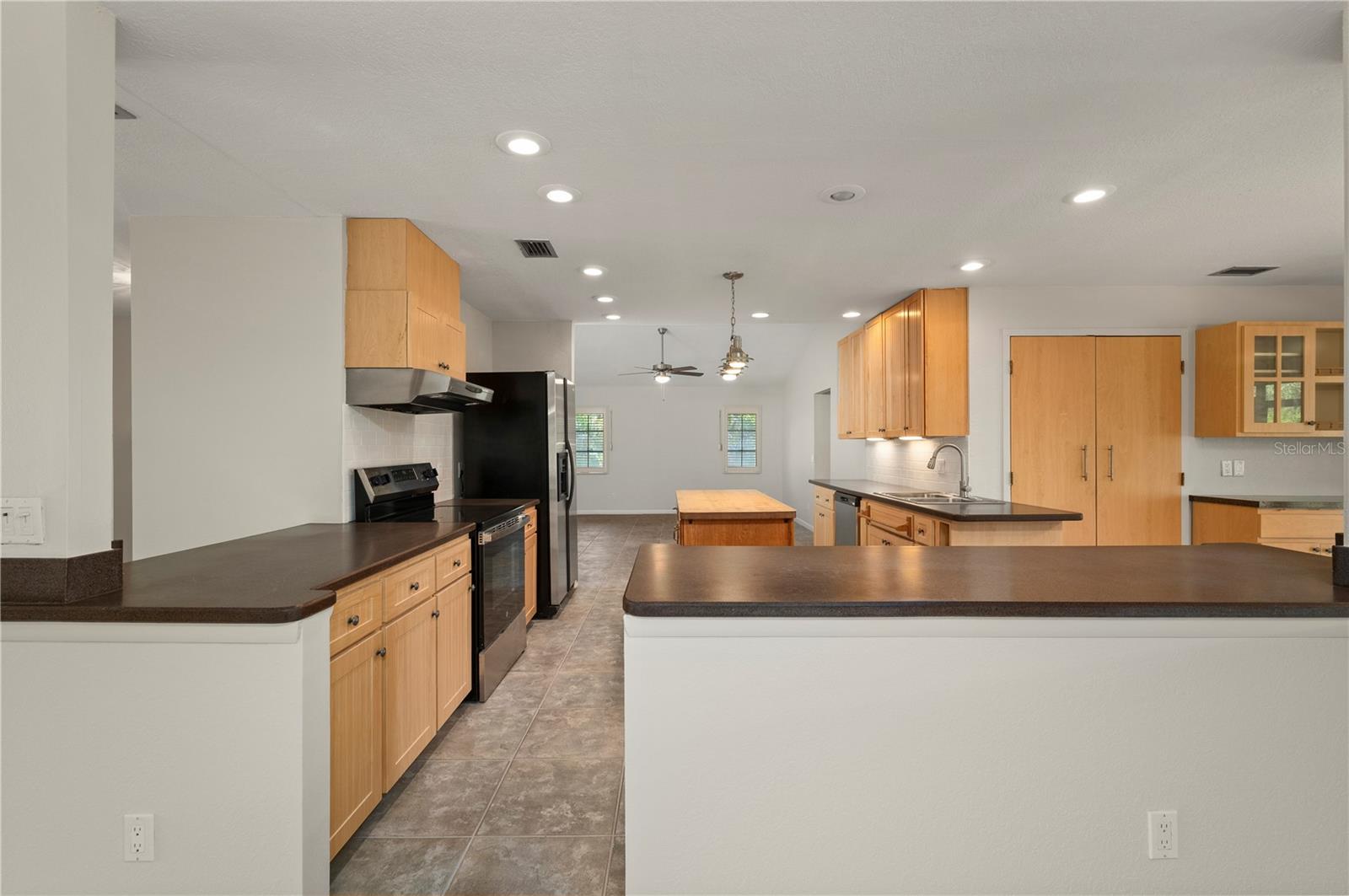 View of the kitchen from the dining area and entry to the Family Room - 17356 GULFSPRAY CIR, PORT CHARLOTTE