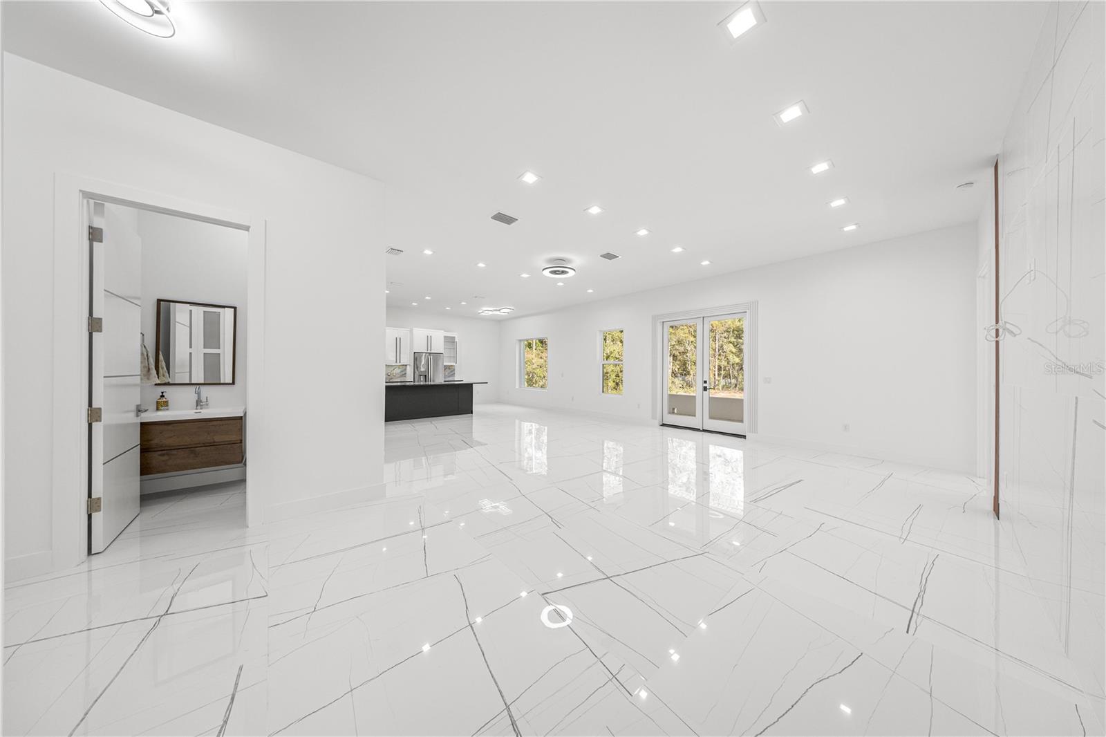VIEW OF HALF BATHROOM AND OPEN LIVING AREA W/KITCHEN - 6877 SW 131ST CIR, OCALA