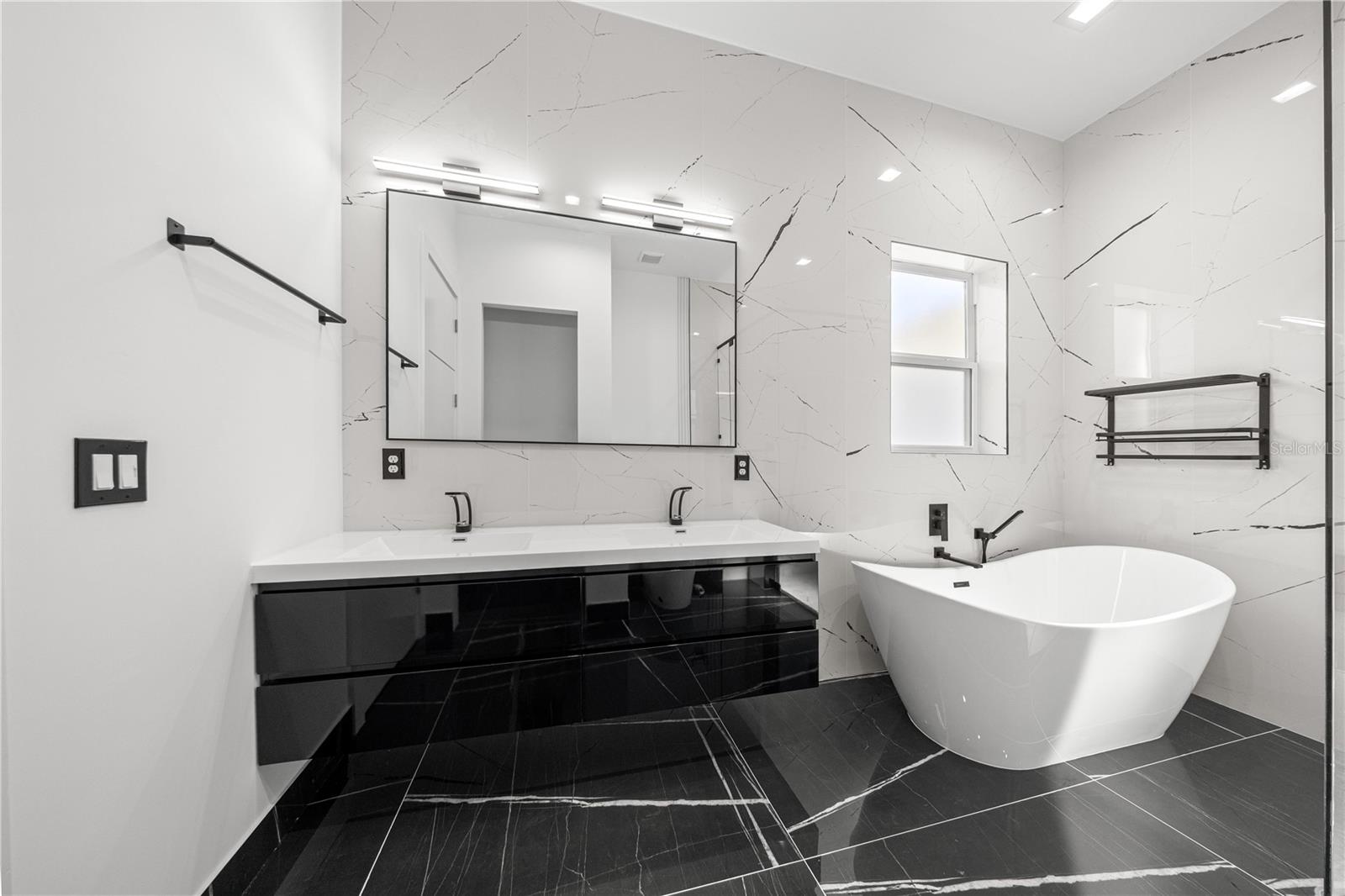 PRIMARY BATHROOM - FREE-STANDING BATHTUB AND WALL-MOUNTED DUAL SINK VANITY - 6877 SW 131ST CIR, OCALA