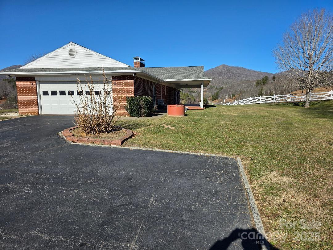 South view of house including parking area and 2-car garage - 1375 E US Highway 19E Highway, Burnsville