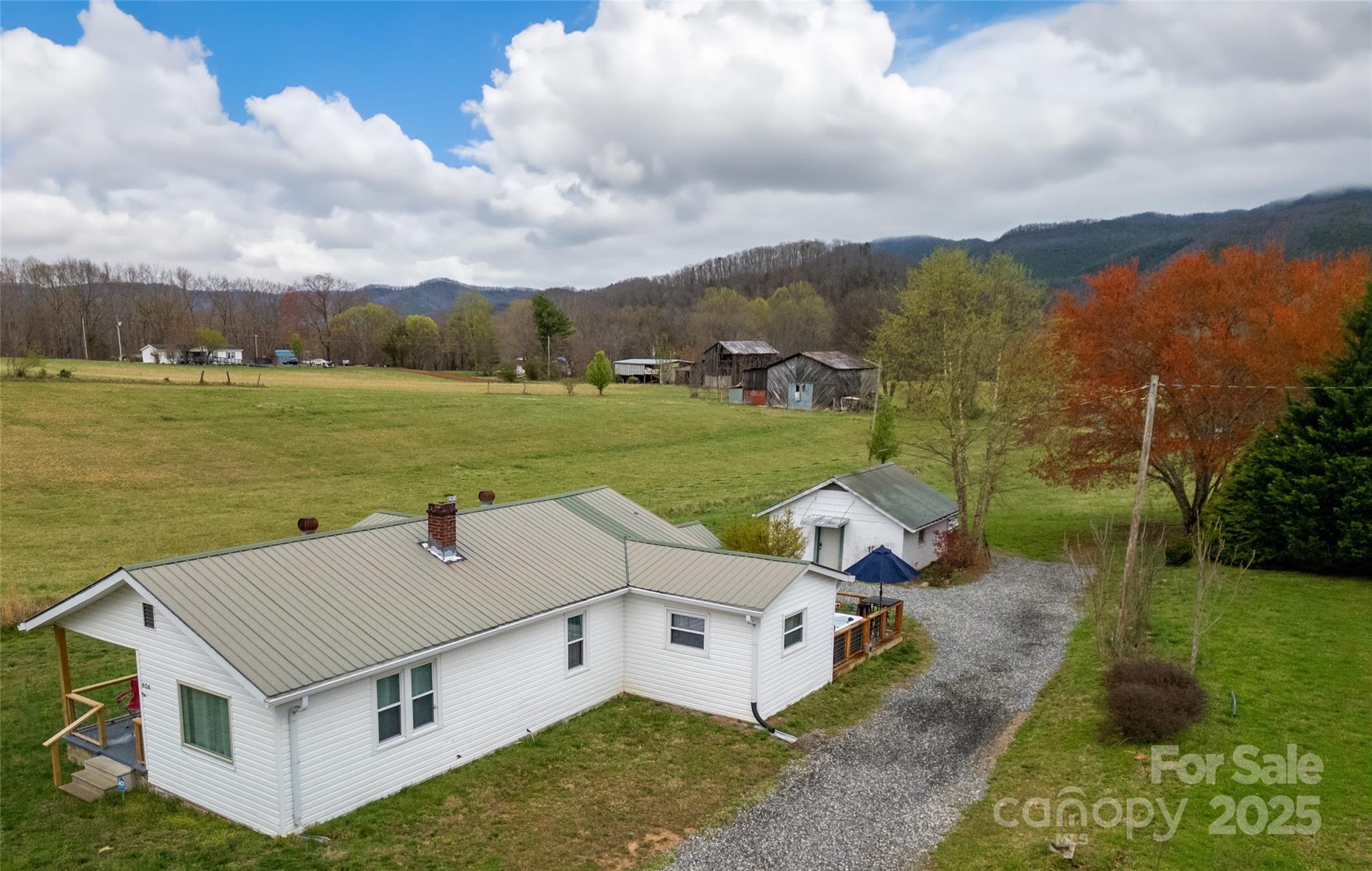 House Side from above street. Red Maple and Birch Trees in Spring. Meadow, Barns and Mountains beyond. - 626 Fairview Loop, Hot Springs