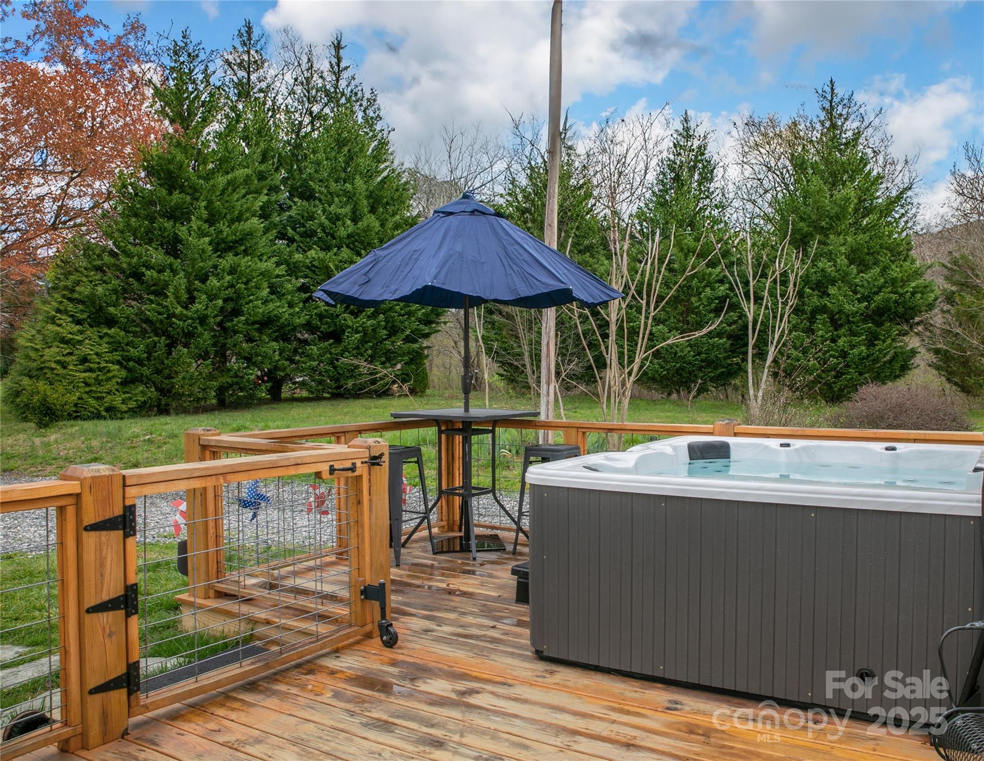 Rear Deck with the hot tub and high-top table on its left side. - 626 Fairview Loop, Hot Springs