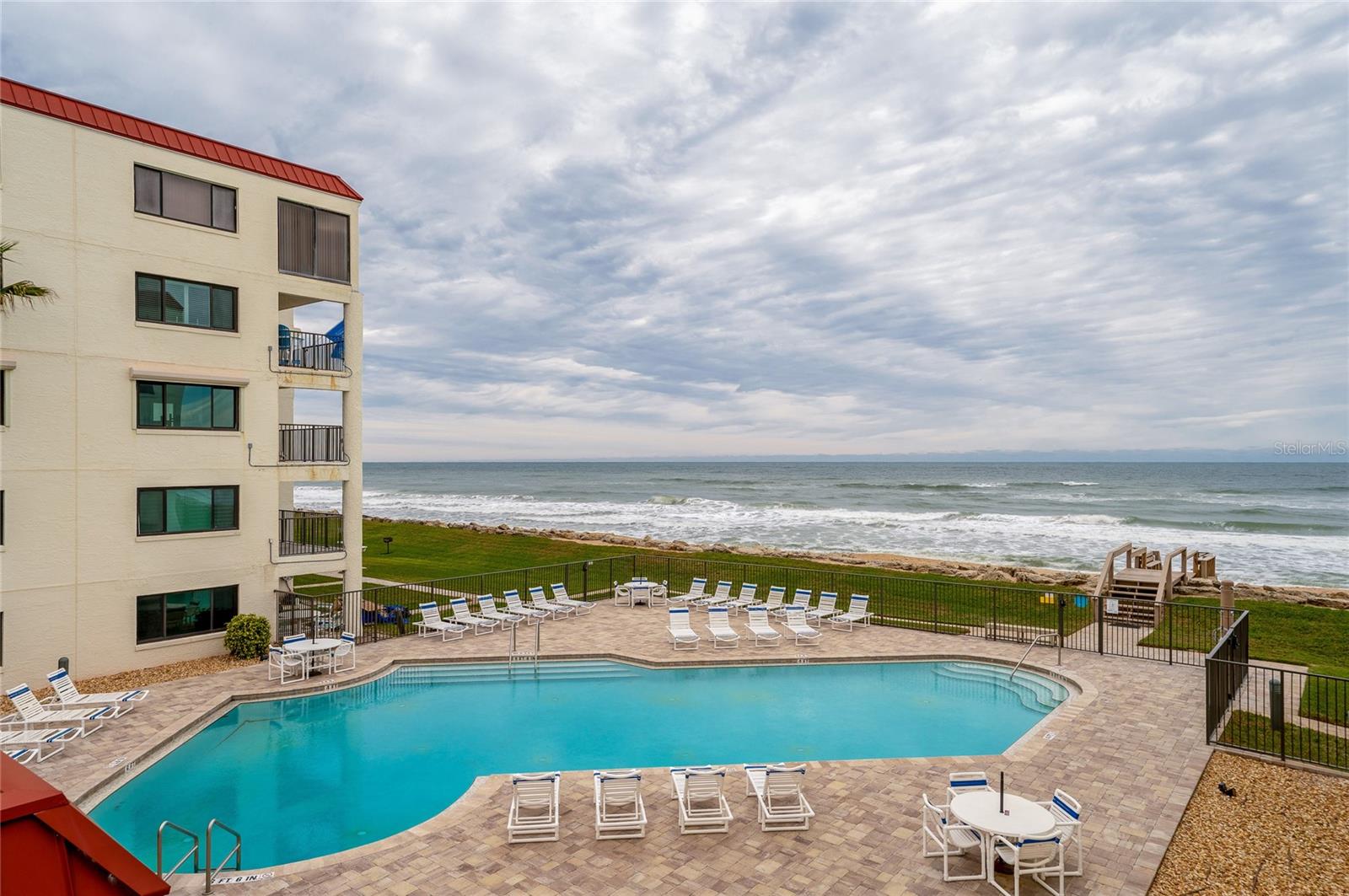 The oceanfront pool area features ample seating, a paved sun deck, and gated access to the beach—designed for relaxing and recreation. - 6727 TURTLEMOUND RD #315, NEW SMYRNA BEACH