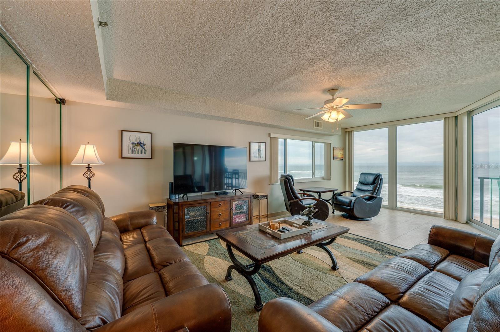 The living area features full-length windows with unobstructed ocean views and access to the balcony an ideal setting for relaxing or hosting guests. - 6727 TURTLEMOUND RD #315, NEW SMYRNA BEACH