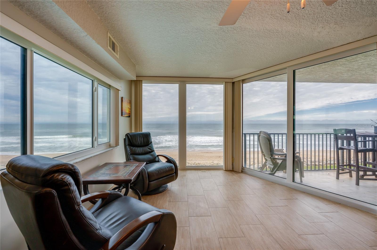 A light-filled corner retreat with panoramic ocean views through wraparound windows. This flexible space is perfect for morning coffee, reading, or enjoying the serene beachfront setting. - 6727 TURTLEMOUND RD #315, NEW SMYRNA BEACH