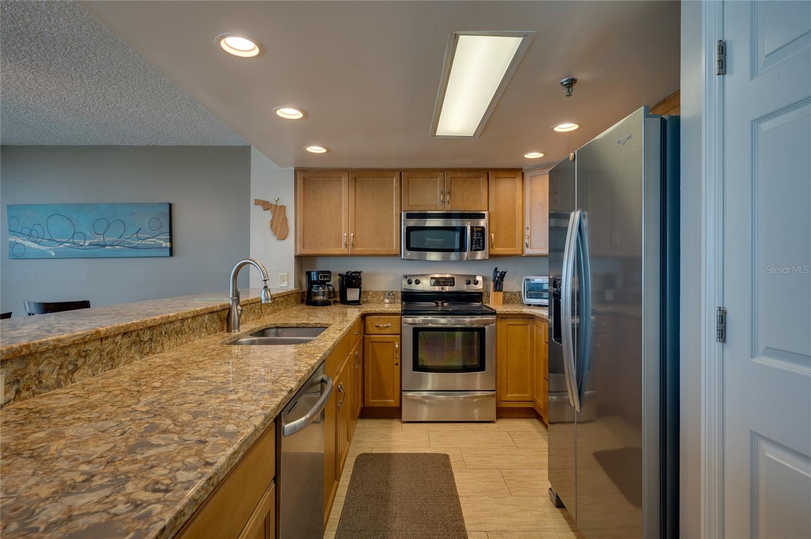 The L-shaped layout maximizes counter space and efficiency and recessed ceiling lights for a bright and modern feel. - 6727 TURTLEMOUND RD #315, NEW SMYRNA BEACH