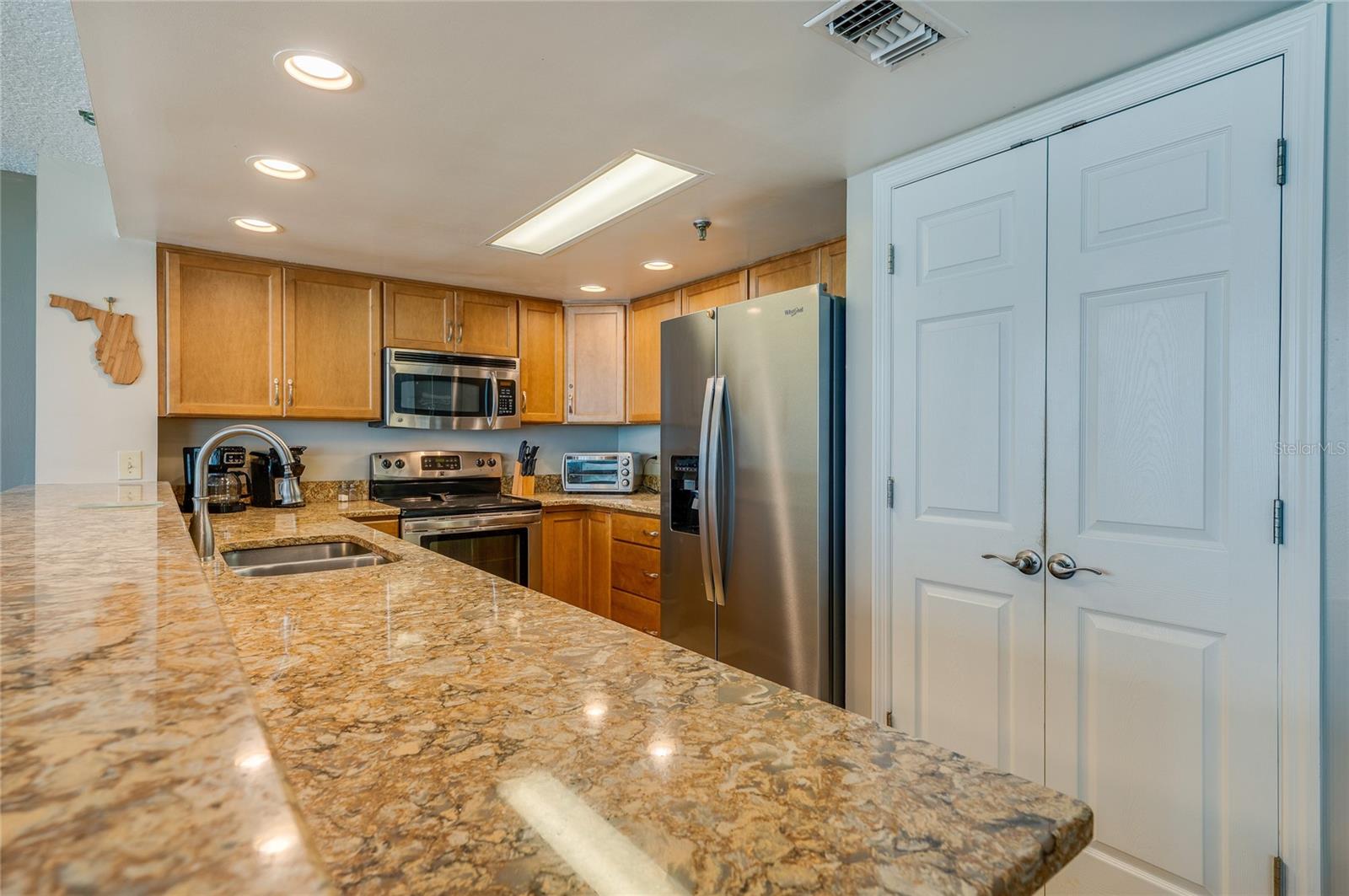 Stainless steel appliances and abundant cabinetry make this kitchen as functional as it is stylish. - 6727 TURTLEMOUND RD #315, NEW SMYRNA BEACH