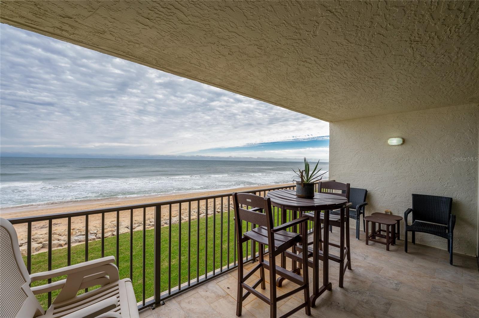 The private covered balcony offers a front-row seat to the Atlantic, with space for dining or lounging while taking in uninterrupted ocean views and the sound of crashing waves. - 6727 TURTLEMOUND RD #315, NEW SMYRNA BEACH