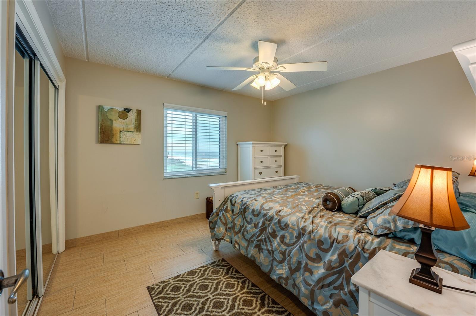 This additional bedroom features soft natural light, a ceiling fan, and ample space, making it ideal for guests or multi-use as a home office or retreat. - 6727 TURTLEMOUND RD #315, NEW SMYRNA BEACH