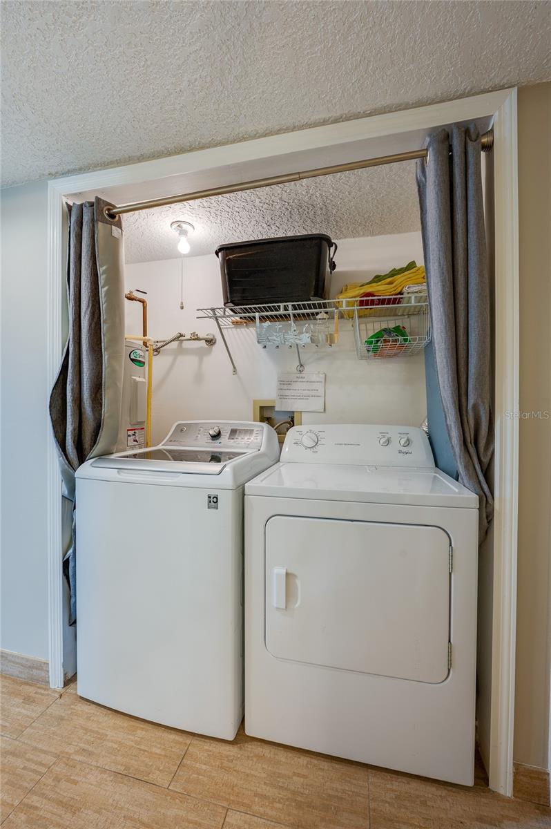 The in-unit laundry area includes a full-size washer and dryer, with open space above—ideal for future DIY shelving or storage customization. - 6727 TURTLEMOUND RD #315, NEW SMYRNA BEACH