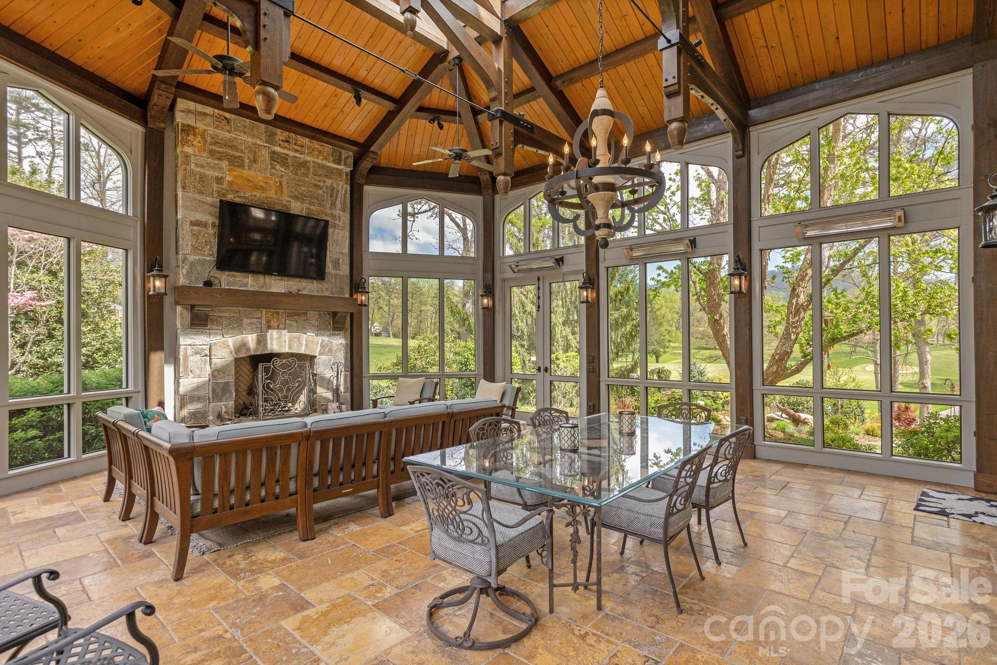 Screened porch with fireplace, dining area, and golf course views - 8 Fairway Place, Asheville