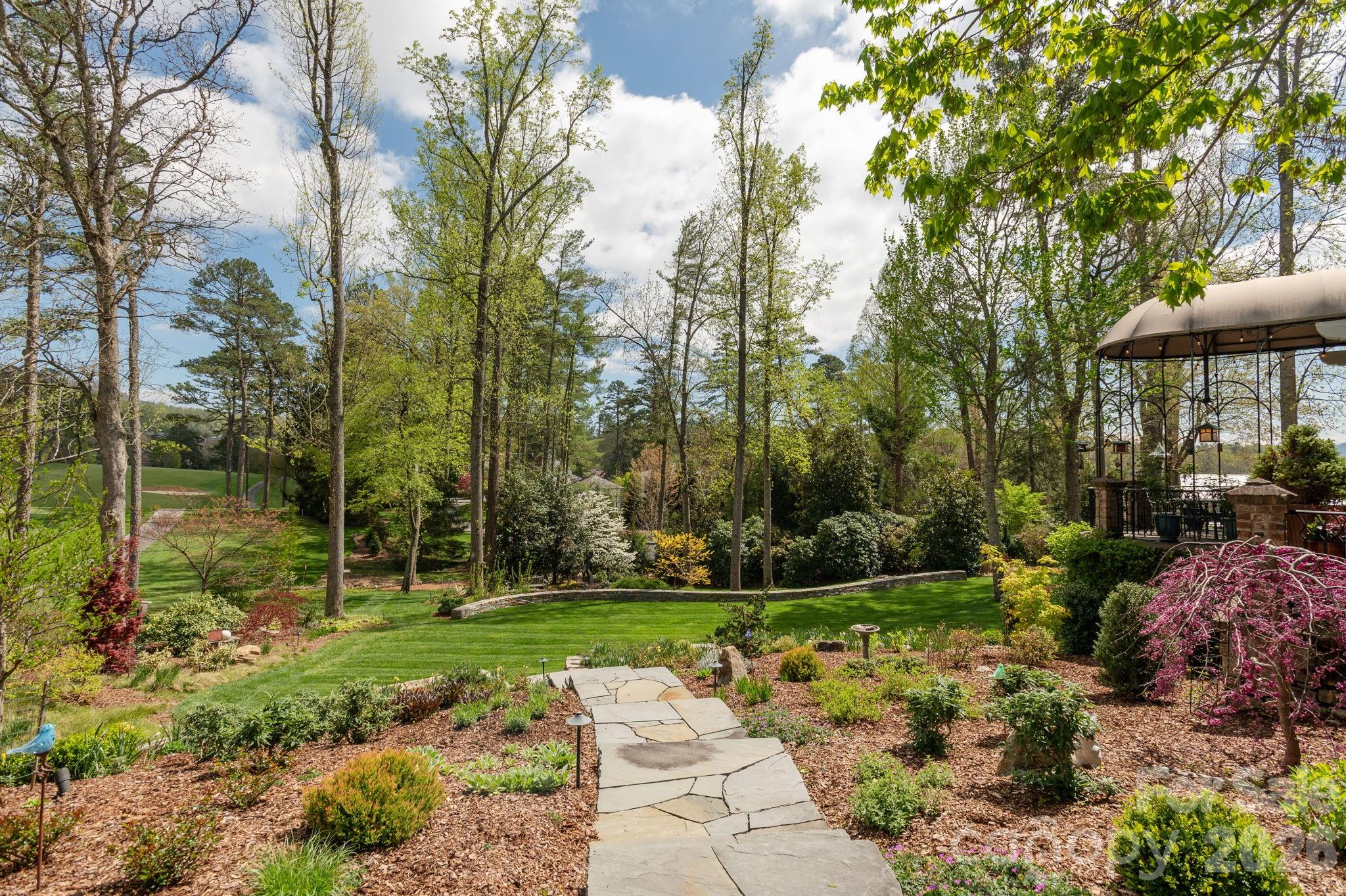 Winding stone pathways connect the gardens and outdoor living spaces - 8 Fairway Place, Asheville