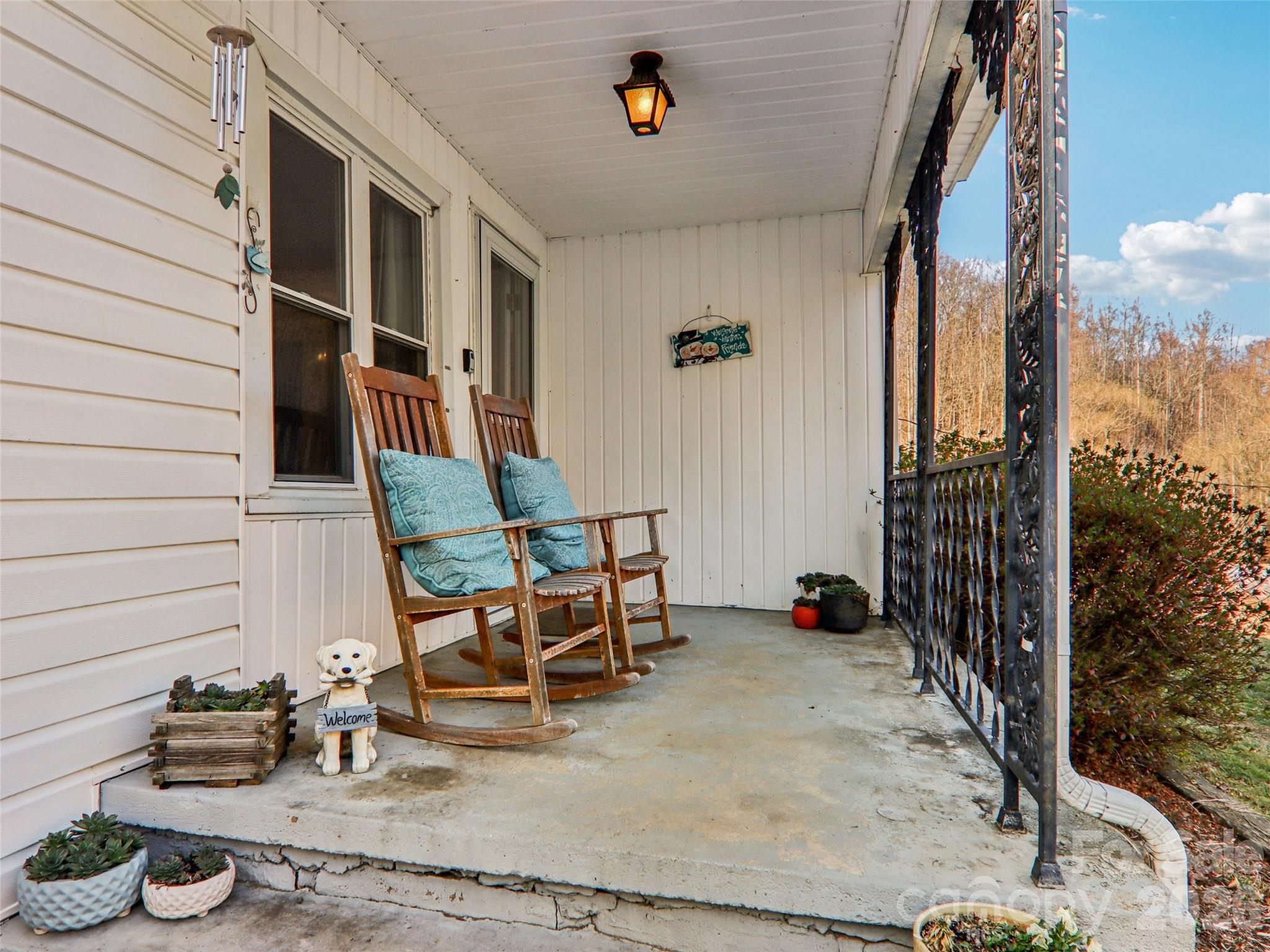 Covered front porch offering a comfortable space to relax and enjoy the peaceful setting and views of the front yard. - 7 Landon Mountain Lane, Weaverville