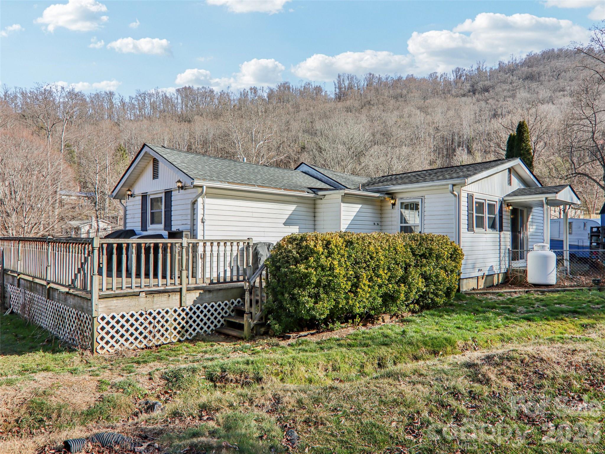 Rear view of the home with wraparound deck and back porch - 7 Landon Mountain Lane, Weaverville
