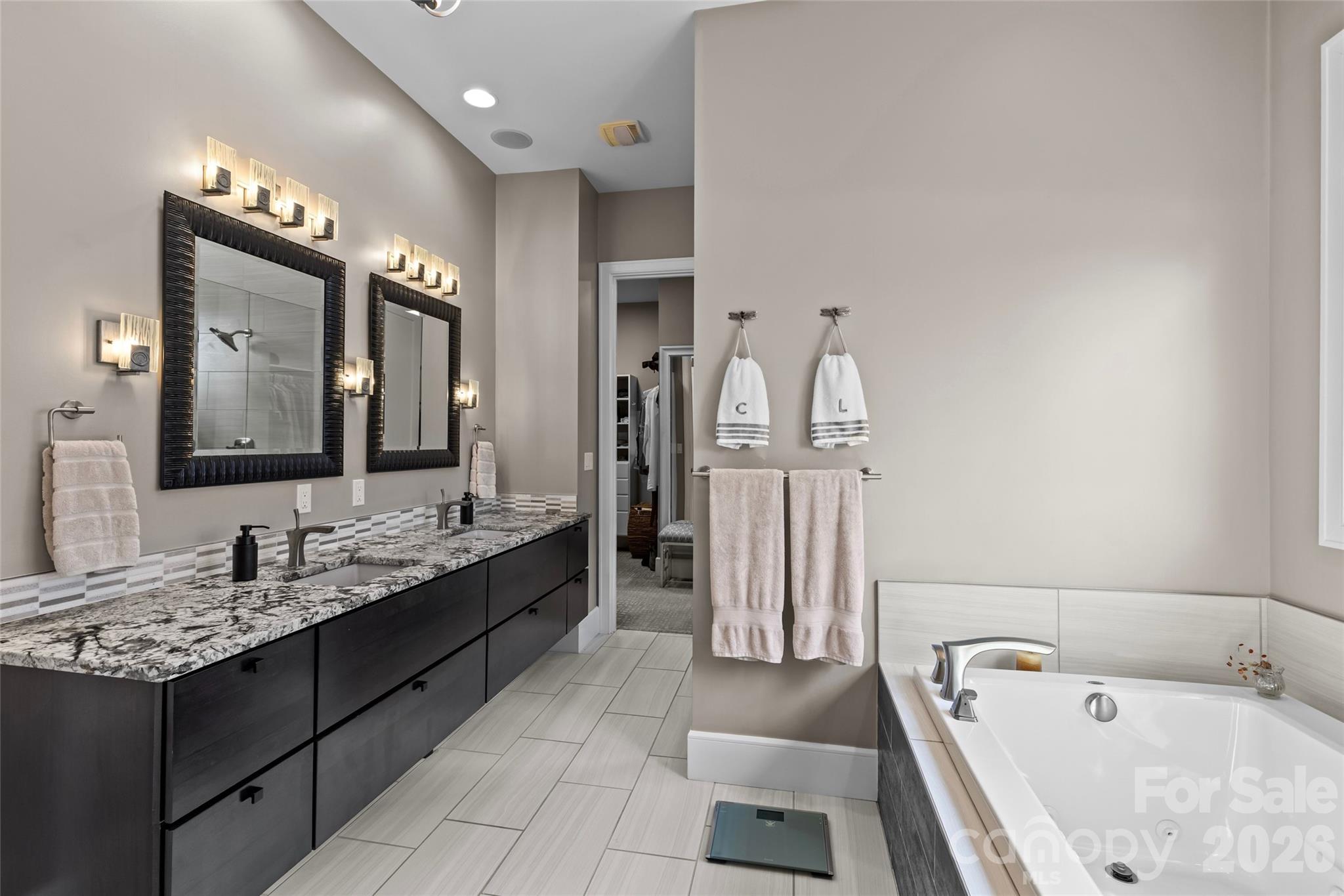 Primary suite has stunning lake views, gas fireplace, sitting area/office, double vanity, shower, bathtub, water closet & walk-in closet with access to the laundry room. - 6032 Headlands Court, Belmont