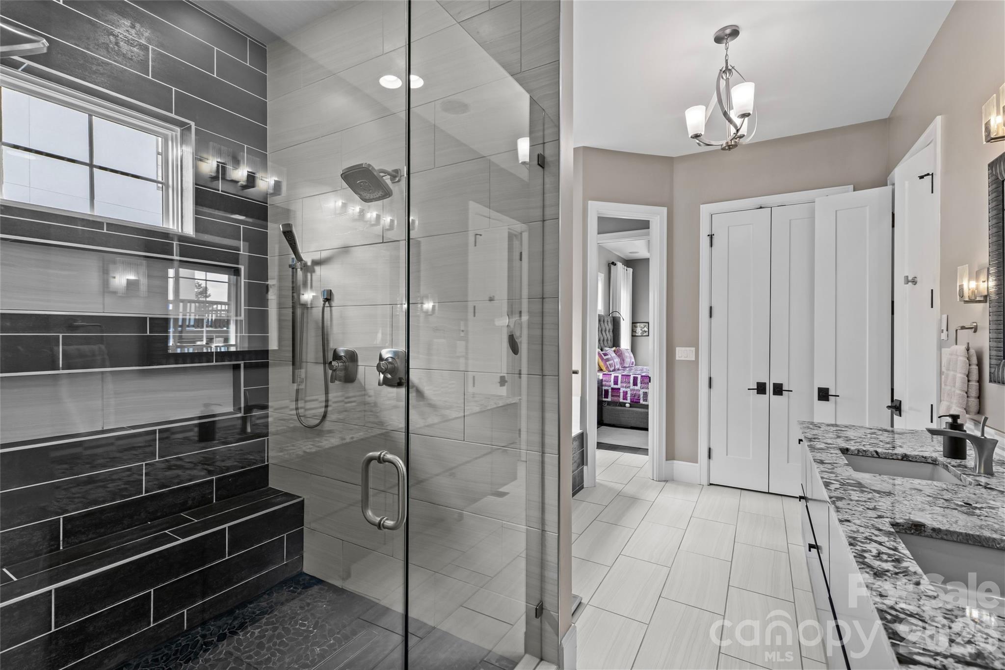 Primary suite has stunning lake views, gas fireplace, sitting area/office, double vanity, shower, bathtub, water closet & walk-in closet with access to the laundry room. - 6032 Headlands Court, Belmont