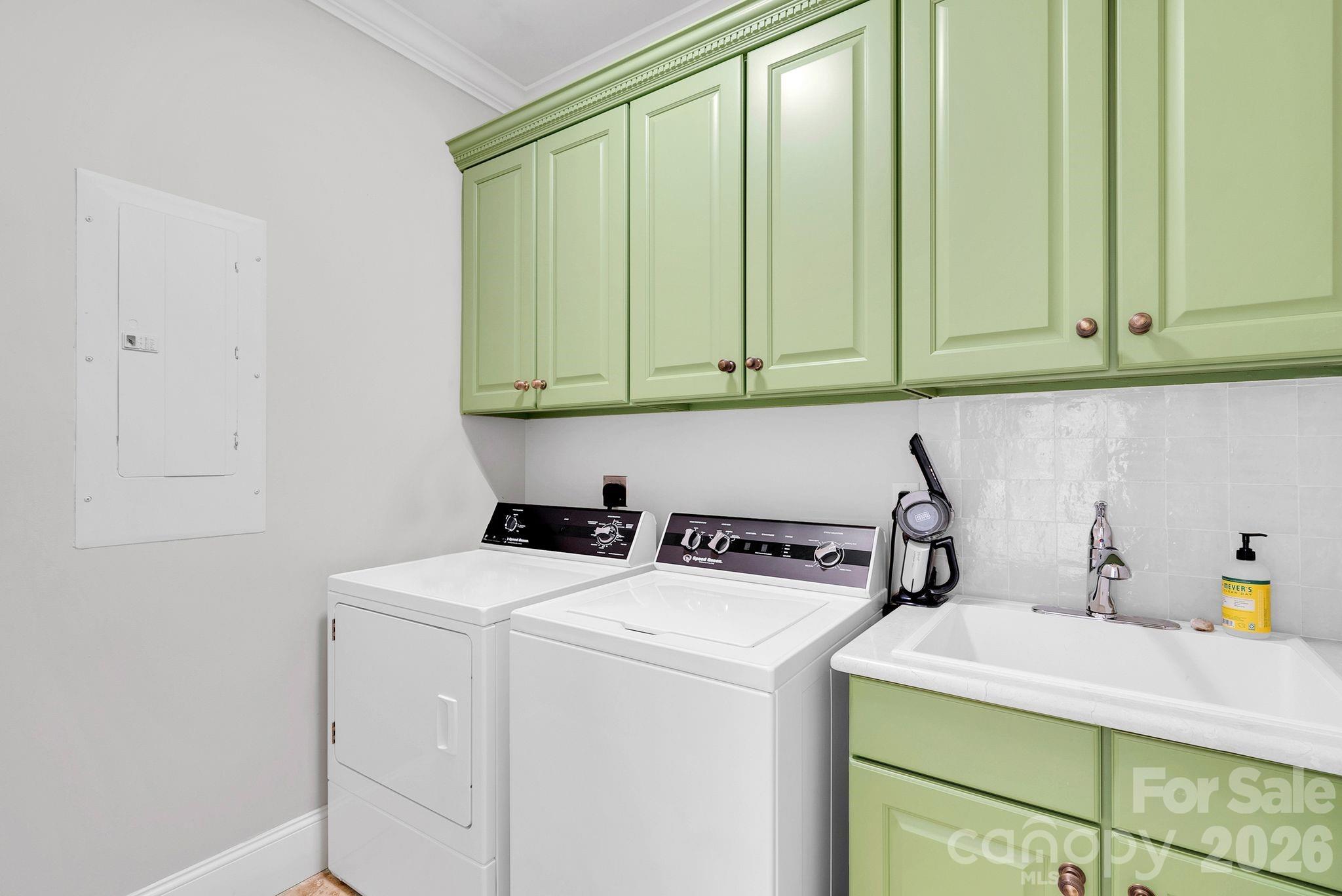 Functional laundry room equipped with washer and dryer connections, utility sink, and built-in cabinetry for storage (washer & dryer do not convey) - 7778 Burning Ridge Drive, Stanley