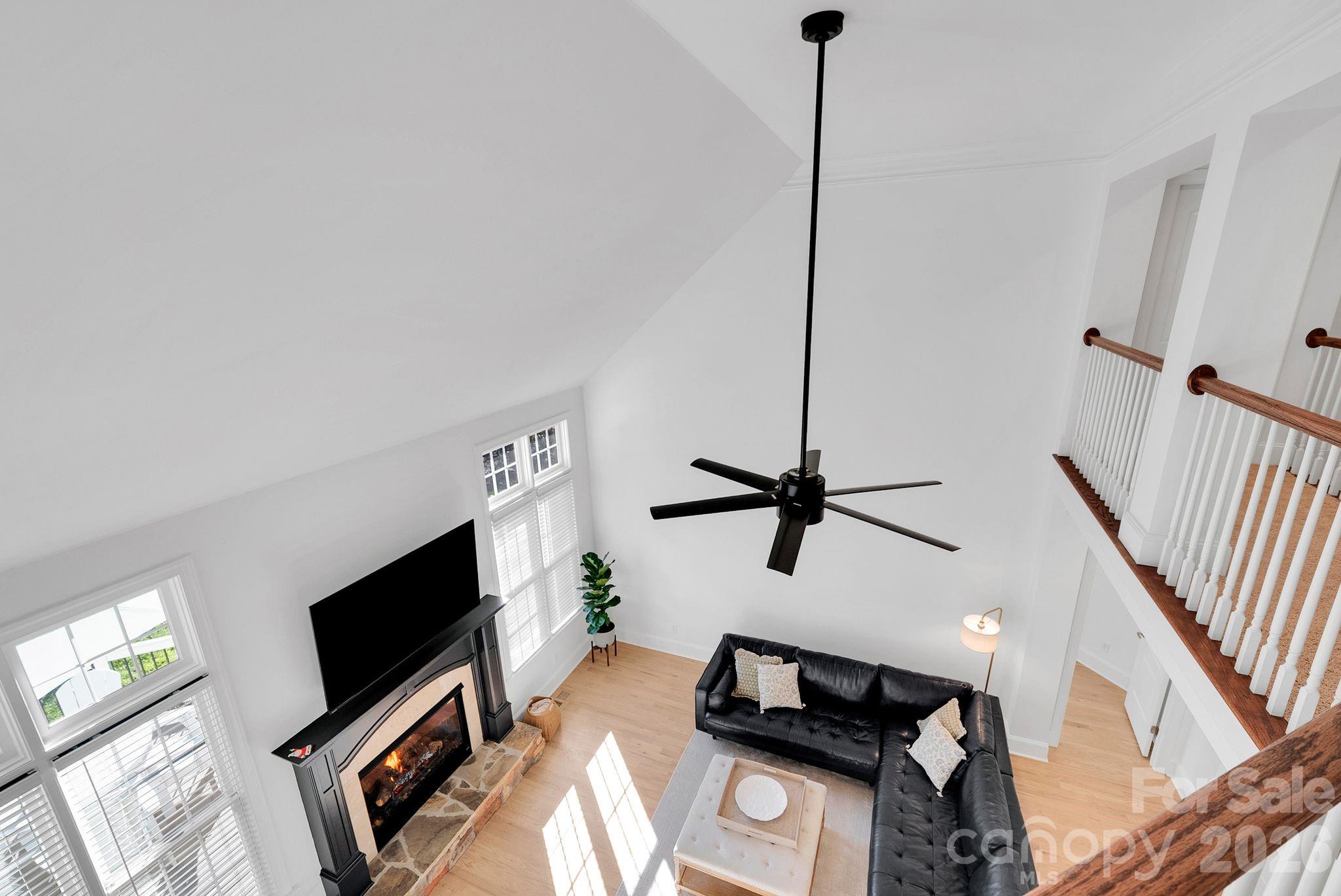 Alternate view of the living room emphasizing the open-concept layout and overlook from the upper level. Seamless flow connects living, dining, and kitchen areas - 7778 Burning Ridge Drive, Stanley