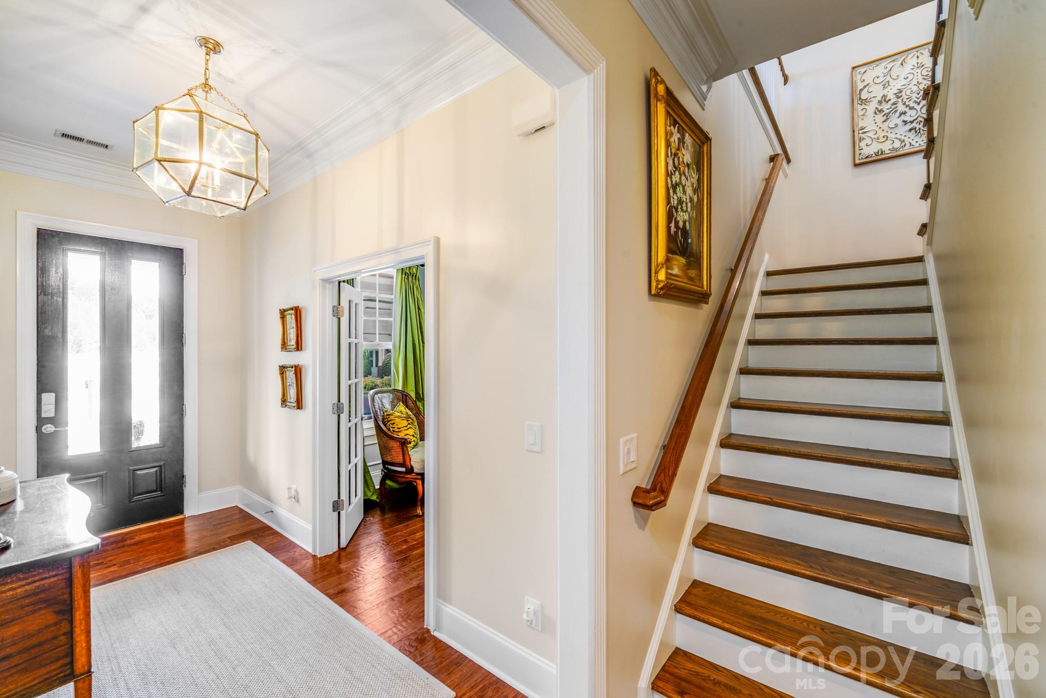 A classic wood staircase with white risers and stained treads leads to the home’s upper-level bedrooms and loft - 2702 Arsdale Road, Waxhaw