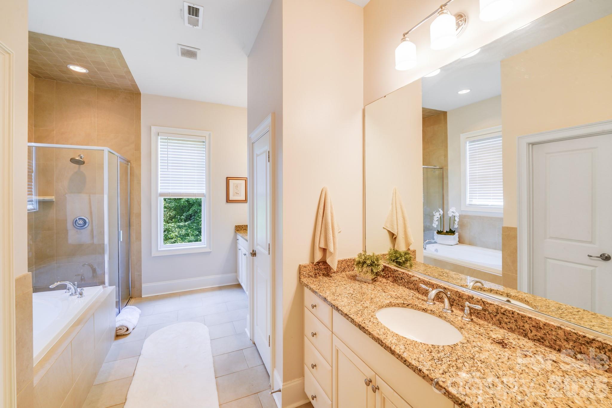 This spacious and elegant primary bathroom offers a spa-like experience with high-end finishes and thoughtful design - 2702 Arsdale Road, Waxhaw