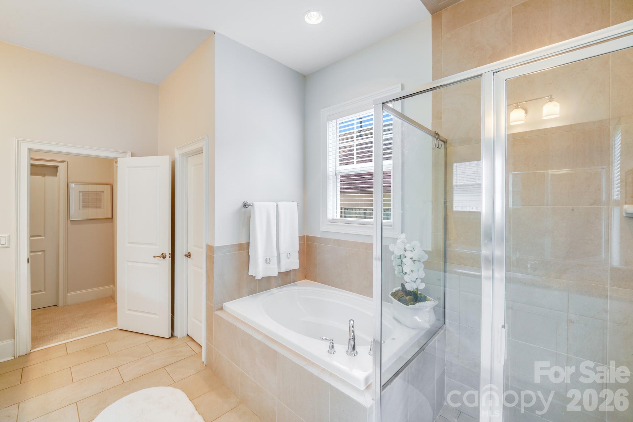 This secondary view of the primary en-suite bath highlights its spa-inspired design and spacious layout. - 2702 Arsdale Road, Waxhaw