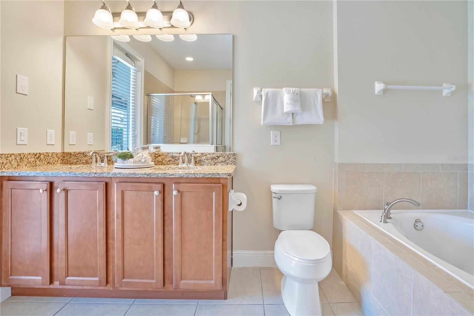 Bright, well-appointed bathroom offering generous vanity space and modern finishes with Access to Lanai and Pool Area - 631 LASSO DR, KISSIMMEE