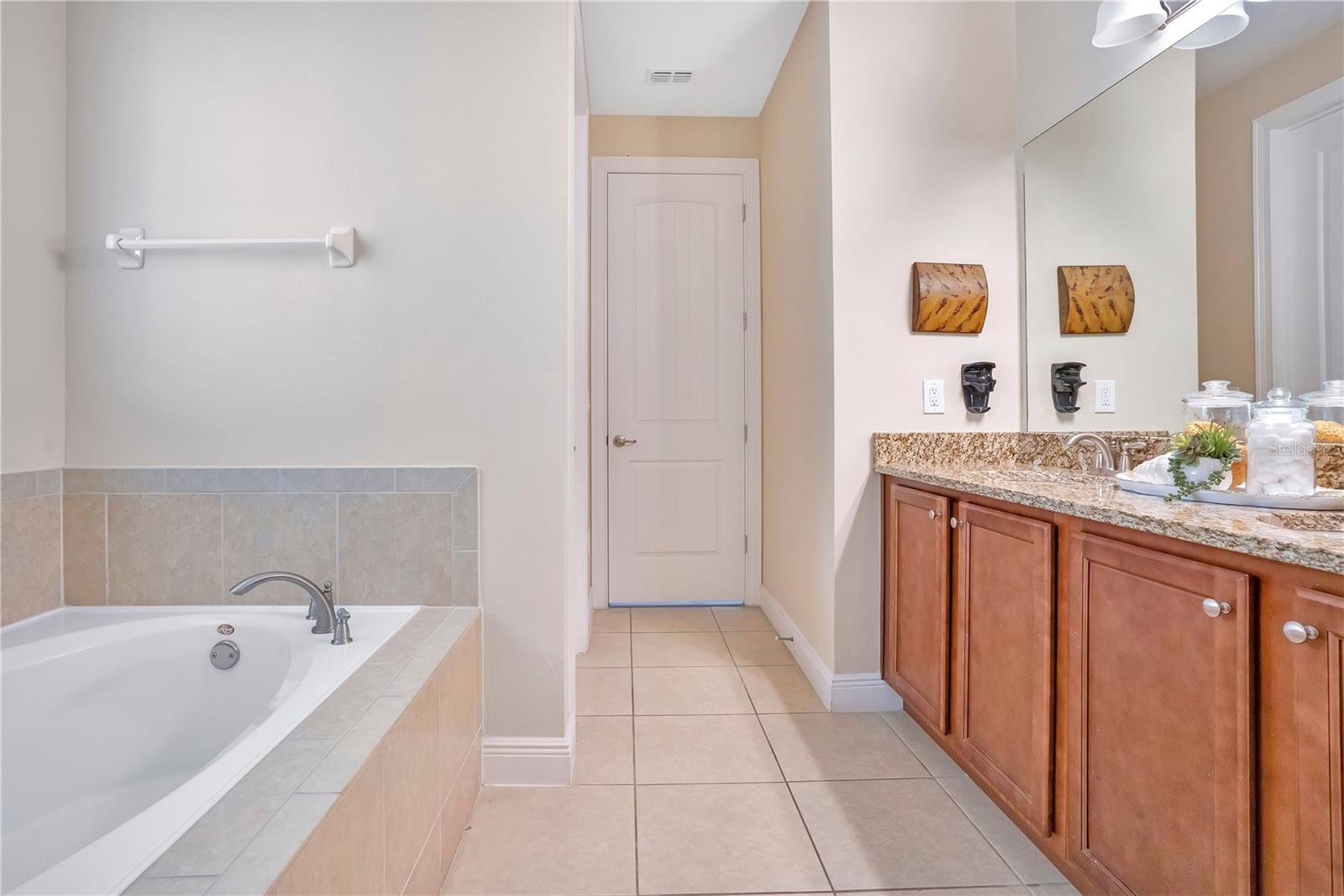 Expansive primary bath featuring dual vanities, soaking tub, and walk-in shower - 631 LASSO DR, KISSIMMEE