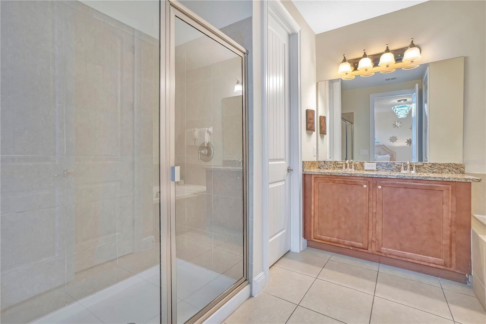 Private bath with granite vanity and glass enclosed shower serving the themed suite - 631 LASSO DR, KISSIMMEE