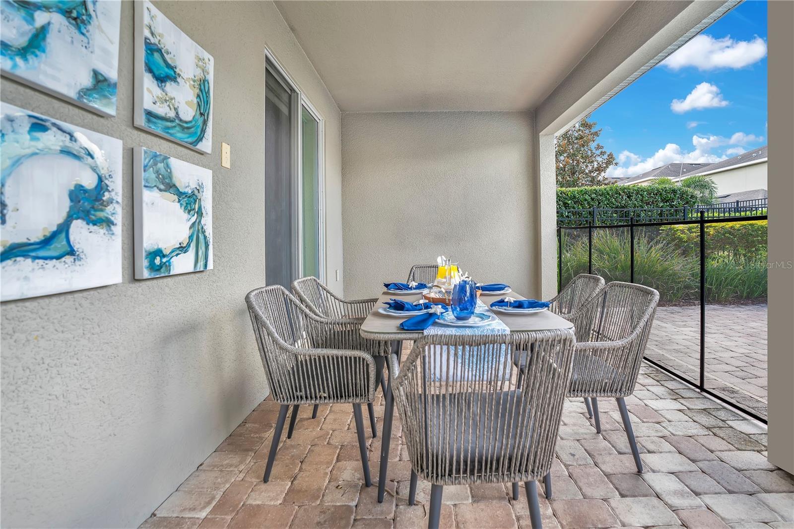 Covered lanai dining space ideal for al fresco meals with views of the private pool and patio - 631 LASSO DR, KISSIMMEE