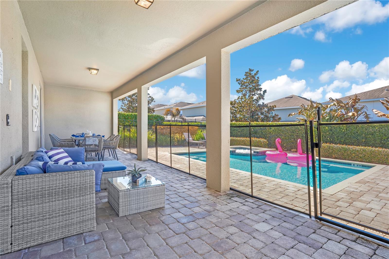 Spacious covered outdoor lounge area designed for shaded relaxation and year-round enjoyment - 631 LASSO DR, KISSIMMEE