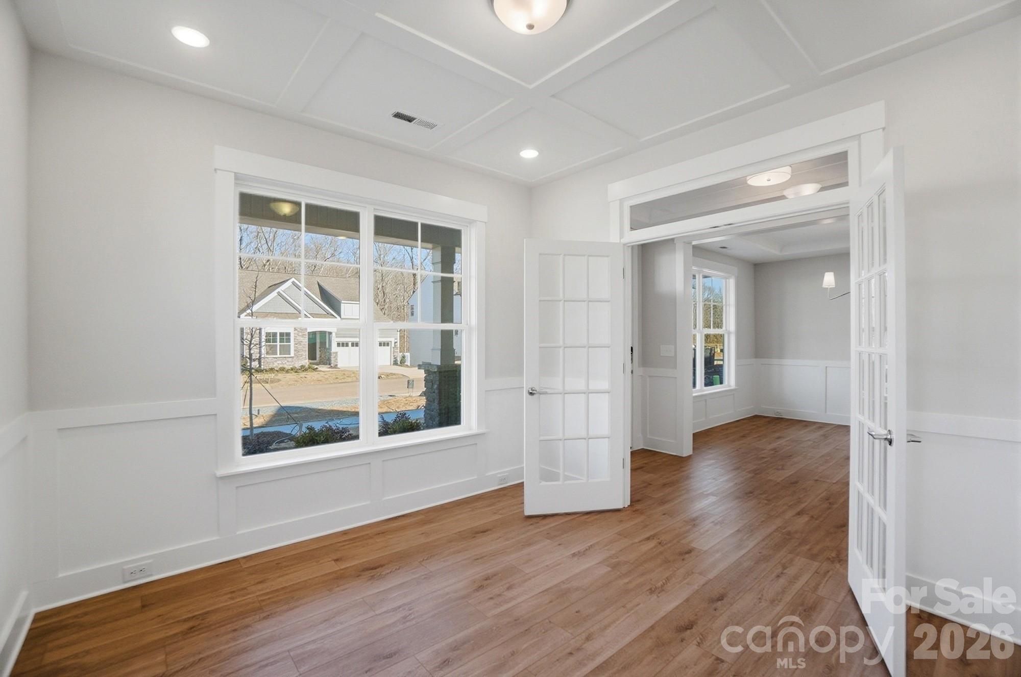Office with faux coffered ceiling, French doors, and wainscoting - 5054 McLaughlin Loop, Waxhaw