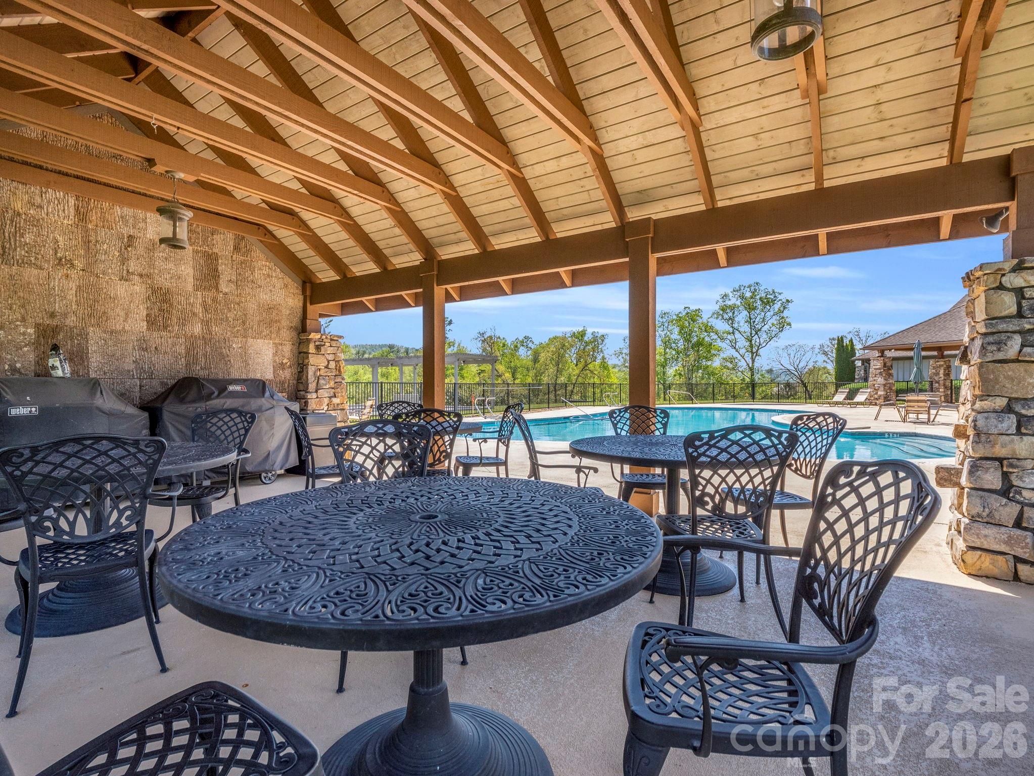 Outdoor pool offers a beautiful covered sitting area with tables and chairs - 142 Mountain Elder Lane, Hendersonville