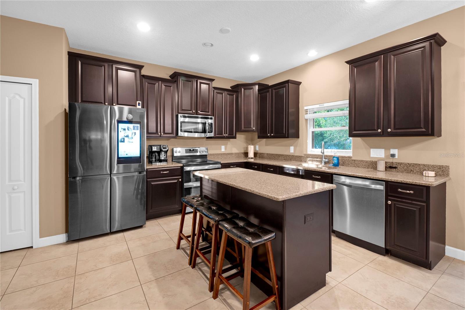 Kitchen has dark wood finishes and stainless steel appliances. - 1301 GLENEAGLES LN, DAVENPORT