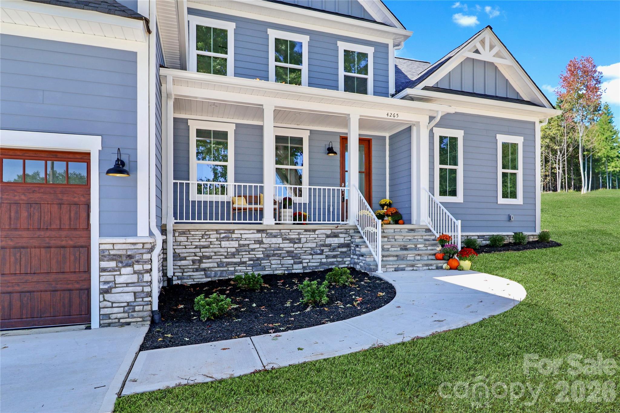 A welcoming front porch invites family and friends with charm. This space is designed to be an extension of the home, offering a comfortable area for relaxation and socializing. - 4265 Candlewood Drive, Sherrills Ford