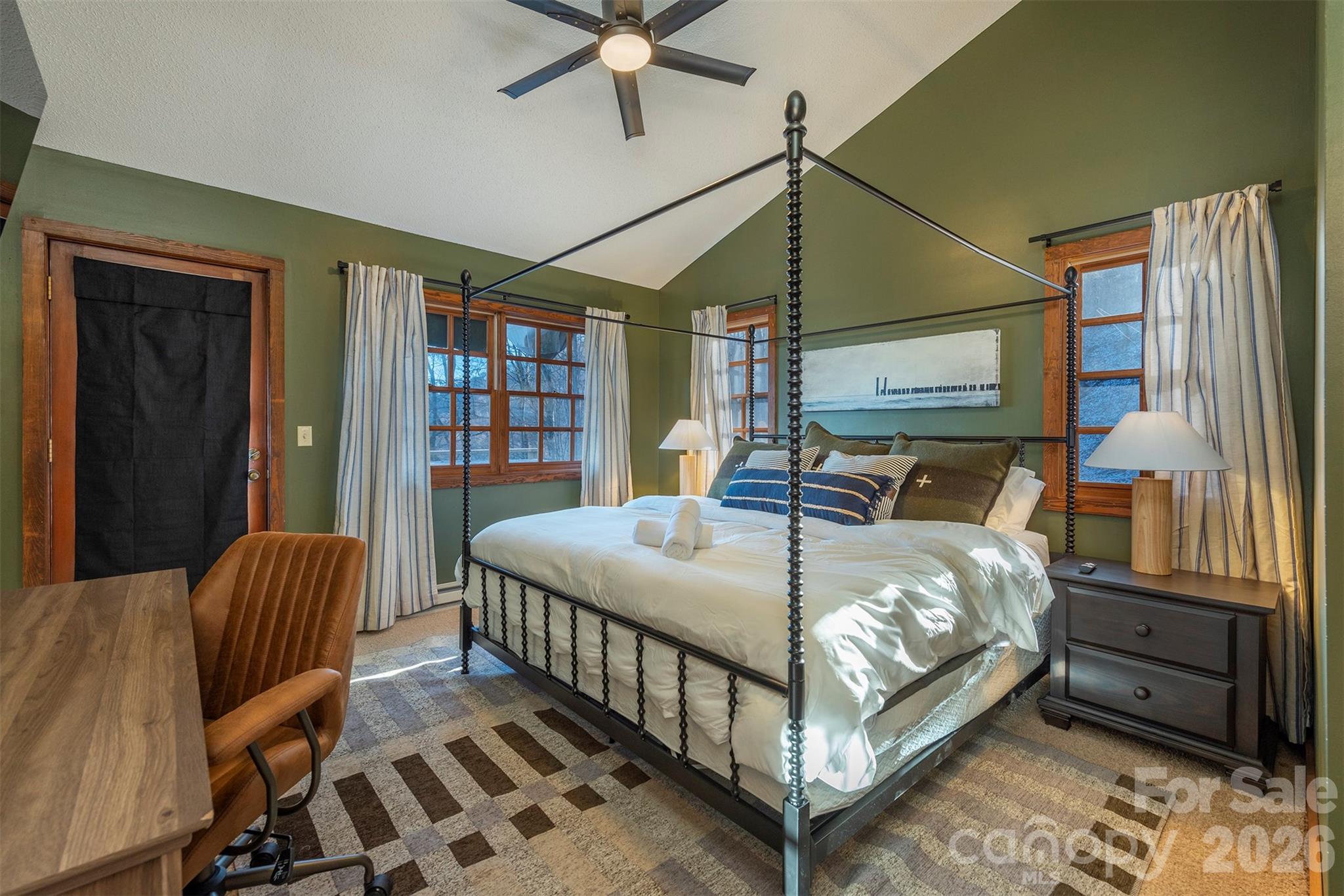 Main floor primary bedroom. Sleep in comfort on a luxurious king-sized bed, and stay productive with a dedicated workspace designed for your convenience. - 322 Goldenleaf Road, Mars Hill