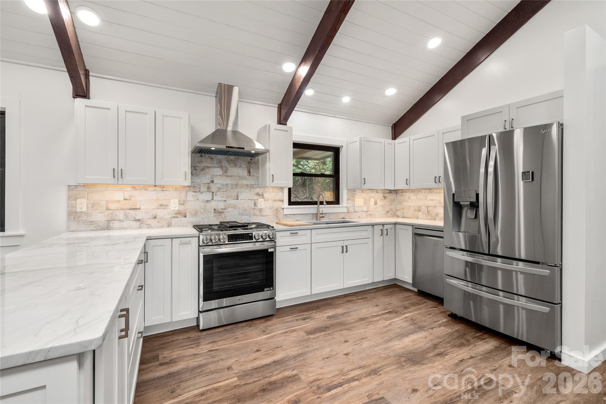 Updated kitchen with generous counter space and modern finishes. - 453 Friendly Acres Drive, Waynesville