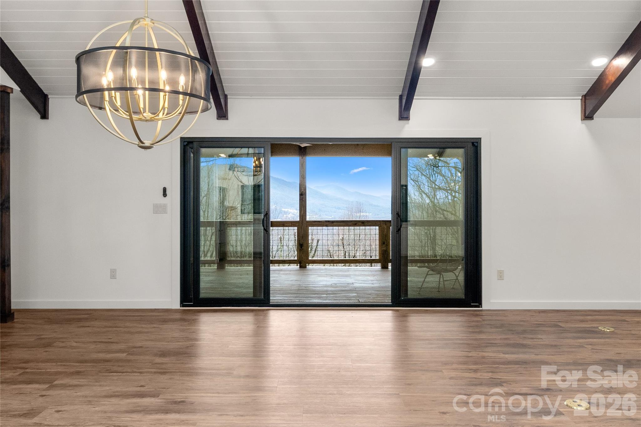 Vaulted great room opens to a covered deck with mountain views. - 453 Friendly Acres Drive, Waynesville
