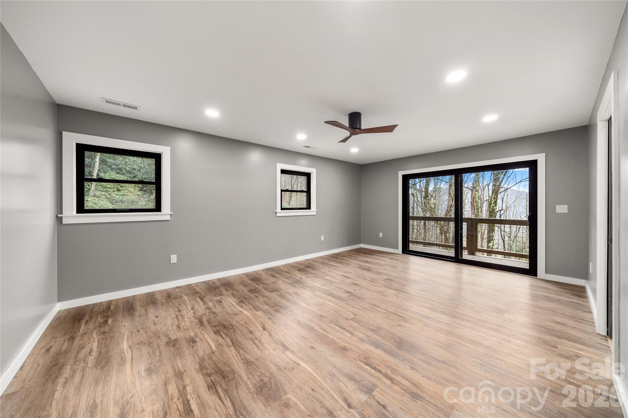 Main level primary bedroom sliding door for fresh mountain air - 453 Friendly Acres Drive, Waynesville