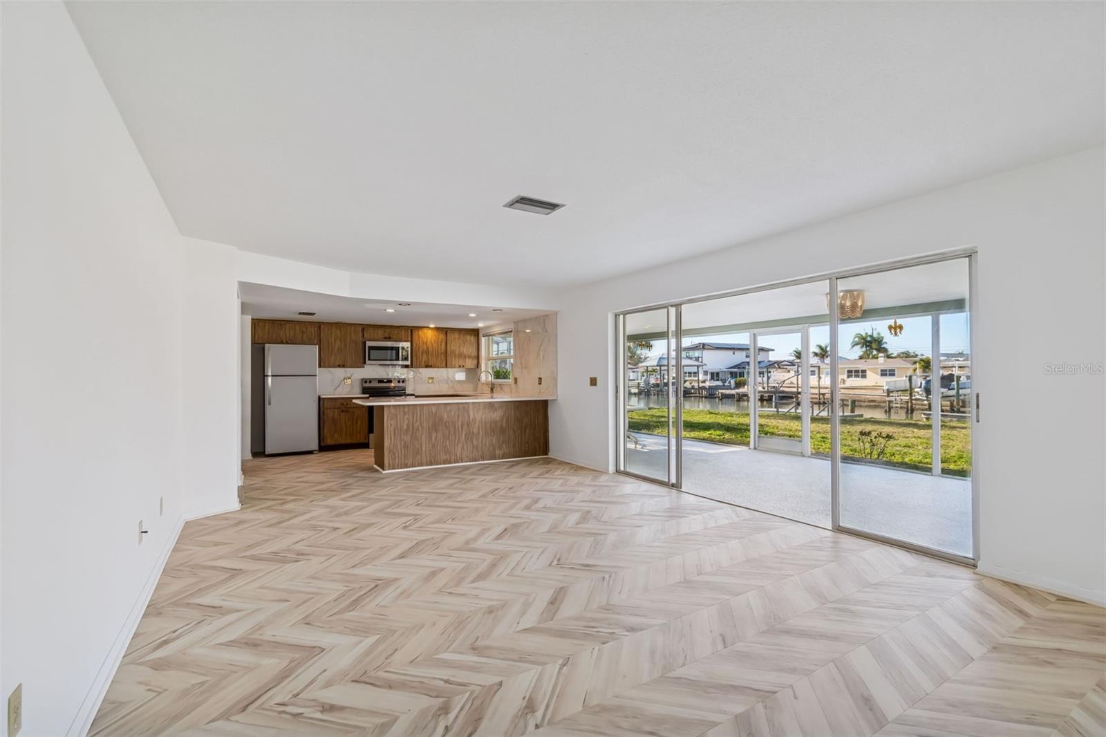 Notice the new chevron design LVP flooring in the family room. - 4415 CLEARWATER HARBOR DR N, LARGO