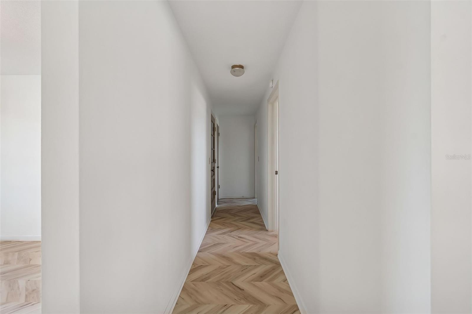 Hall to office, garage and primary suite - 4415 CLEARWATER HARBOR DR N, LARGO