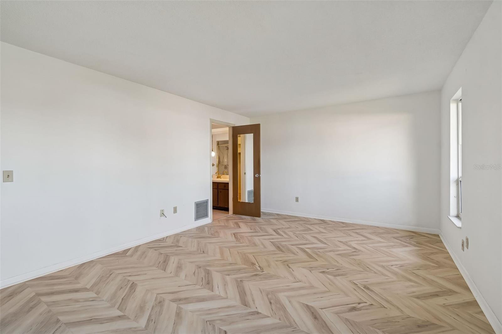 Primary bedroom with door to ensuite bath - 4415 CLEARWATER HARBOR DR N, LARGO