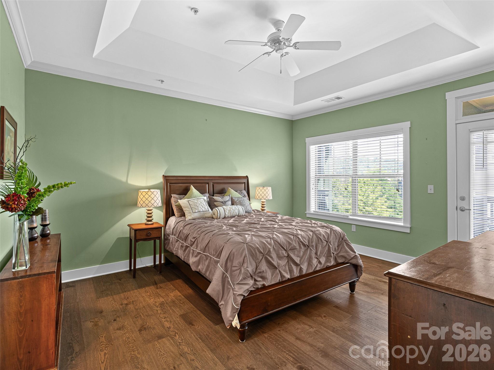 Primary bedroom with door to the balcony with existing furniture. NOT virtually staged. - 9 Kenilworth Knoll, Asheville